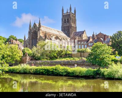 Worcester Cathedral und der Fluss Severn im Frühling, Sonnenschein, klarer blauer Himmel, frische grüne Blätter. Leute, die am Flussufer spazieren. Schön. Stockfoto