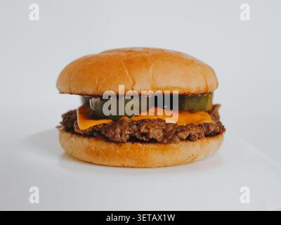 Burger mit Rindfleischpastete, Käse, Gurken und spezieller Sauce auf weißem Hintergrund Stockfoto
