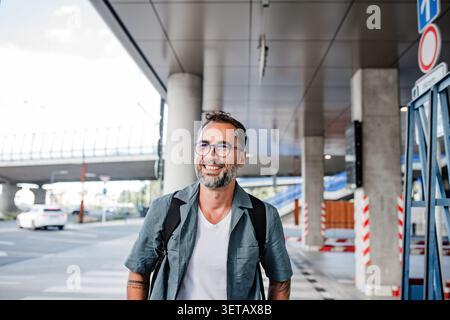 Gutaussehender Mann mit Tattoos, der die Straße runter läuft. Stockfoto