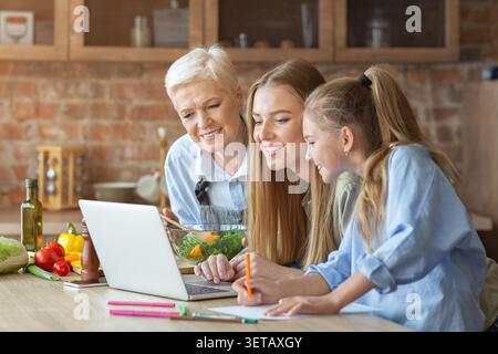Drei Generationen kochen gemeinsam in einer gemütlichen Küche und genießen eine gesunde Mahlzeit Zubereitung Stockfoto