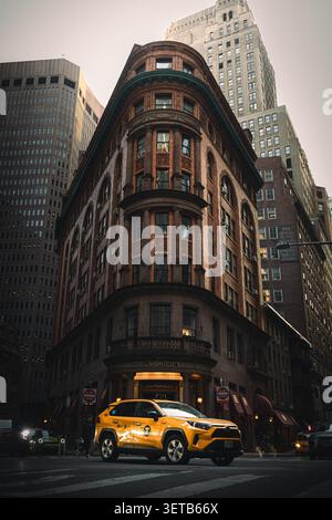 New York, USA - 14. März 2025: Blick auf Delmonico's Restaurant mit einem gelben Taxi auf der Straße vor dem historischen Gebäude in Stockfoto
