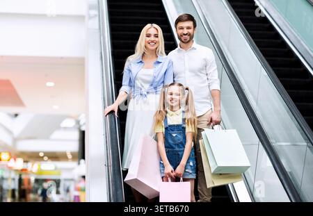 Familieneinkauf in einem Einkaufszentrum mit Taschen am Escalator während eines Wochenendausflugs Stockfoto