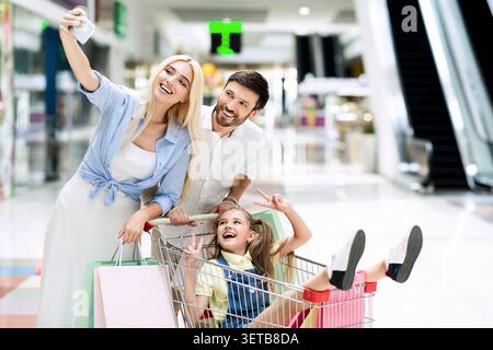 Die Familie genießt Einkaufen und Selfies in einer modernen Mall Stockfoto