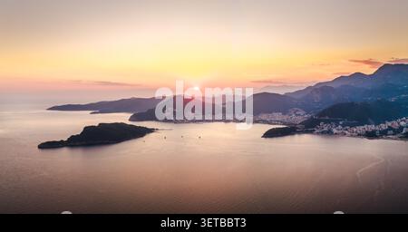 Panorama des Sonnenuntergangs über die Küste der Budva Riviera mit der Insel Sveti Nikola und der Adria in Montenegro Stockfoto