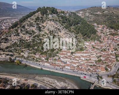 Eine Drohnenaufnahme fängt die historische Stadt Berat, Albanien, mit ihren charakteristischen weißen Häusern aus der osmanischen Ära mit roten Ziegeldächern und dichten pac ein Stockfoto