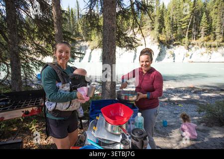 Freunde und Familie kochen auf einem Campingplatz am Fluss Stockfoto
