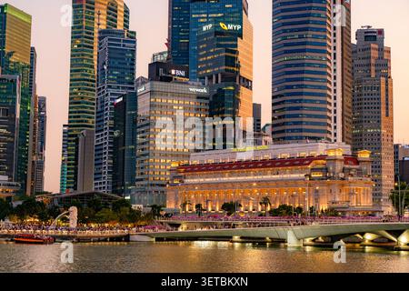 Skyline von Singapur in der Abenddämmerung mit dem historischen Fullerton Hotel und modernen Wolkenkratzern des zentralen Geschäftsviertels in der Marina Bay Area Stockfoto