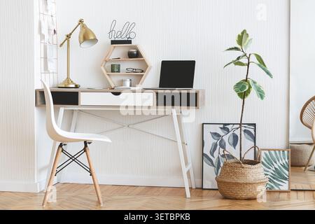 Minimalistisches Home Office-Setup mit natürlichem Licht und Grün in stilvollem Interieur Stockfoto