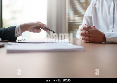 Immobilienmakler und Kunde mit Kredit- oder Versicherungsvertragsdokumenten. Stockfoto