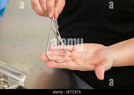 Eine Nahaufnahme eines Zahnarztes, der mit einem Kompasswerkzeug aus Metall während einer Untersuchung misst, um Hygienestandards und technische Genauigkeit in einem Gesundheitswagen hervorzuheben Stockfoto