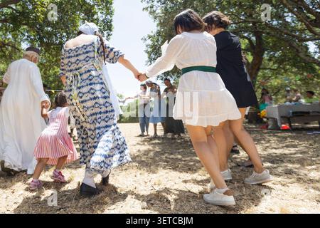 Verschiedene Gruppen genießen traditionellen Volkstanz im Freien Stockfoto