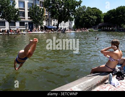 Paris (Frankreich), 21. Juni 2026: Schwimmen im Canal Saint-Martin während einer Hitzewelle. Pariser und Touristen, die die Sonne genießen und kühle Temperaturen suchen Stockfoto