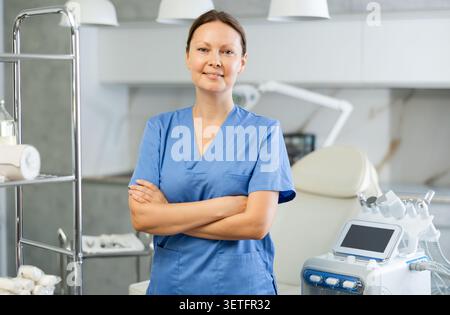 Porträt der Ärztin Kosmetologin in der Praxis der Hardware-kosmetischen Prozedur. Wunderschöne Kosmetikerin in Uniform lächelte, sah in die Kamera und Stockfoto