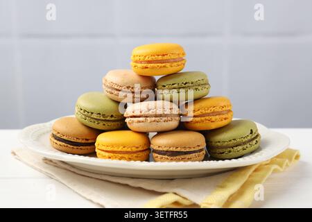 Verschiedene leckere Macarons auf weißem Holztisch, Nahaufnahme Stockfoto