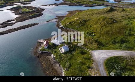 Blick aus der Vogelperspektive auf die abgelegene Siedlung der Lofoten mit traditionellen norwegischen Häusern mit roten Dächern an der felsigen Küste Stockfoto