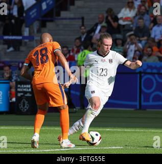 Berlin – 25. Juni 2024: Patrick Wimmer aus Österreich (R, #23) kämpft im Gruppenspiel der UEFA EURO 2024 im Olympiastadion Berlin um einen Ball mit Donyell Malen aus den Niederlanden (Platz 18) Stockfoto