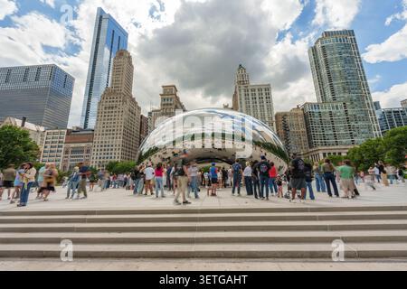 Chicago, USA – 19. Juni 2026 – Besucher treffen sich um die legendäre Cloud Gate Skulptur in Chicago, die die Skyline und die lebhafte Atmosphäre der Stadt widerspiegelt Stockfoto