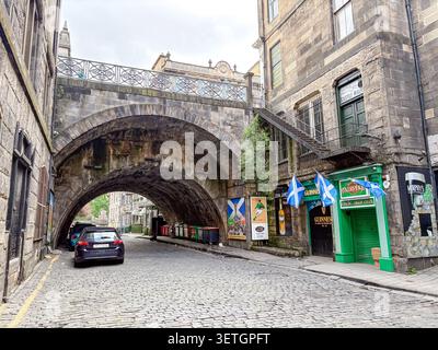Erhöhter Steindamm, der ein tiefes Tal in der Altstadt von Edinburgh, Schottland, durchquert, mit einem Auto, das unter dem Bogen geparkt wird. Stockfoto
