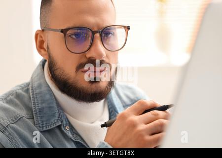 Junger Brillenhändler, der im Büro arbeitet, Nahaufnahme Stockfoto