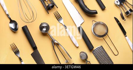 Verschiedene Küchenutensilien und Werkzeuge auf gelbem Hintergrund Stockfoto
