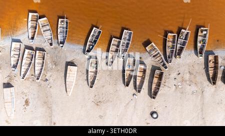 Blick aus der Vogelperspektive auf den Retba-See mit traditionellen Holzfischbooten am Sandstrand in Rufisque, Dakar Region, Senegal. Stockfoto