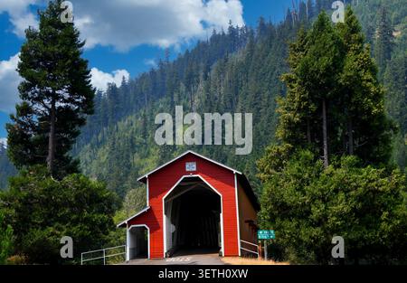 Office Covered Bridge, auch bekannt als Westfir Covered Bridge, ist aus Holz und rot lackiert mit weißen Zierleisten. Es gibt einen überdachten Fußgängerweg Stockfoto