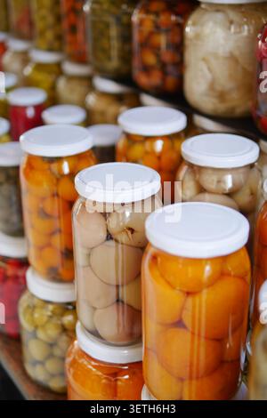 Farbenfrohe Gläser mit konserviertem Obst und Gemüse Stockfoto