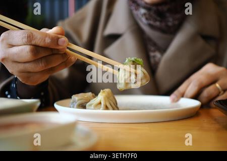 Genießen Sie Klößchen in einem Restaurant mit Essstäbchen Stockfoto