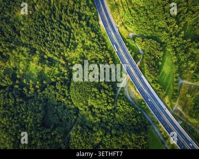 Dramatenansicht aus der Luft auf die Straße mit LKW und vielen Autos und grünem Wald im Sommer.Alpen.Slowenien Stockfoto