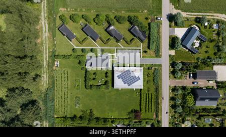 Blick aus der Luft auf moderne Wohnhäuser mit Solarpaneelen auf Dächern, üppige grüne Gärten und gepflegte Hecken in einem Vorstadtviertel in Almere, Stockfoto