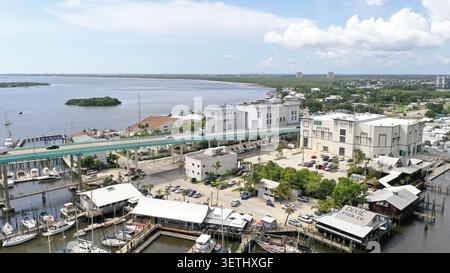 Blick aus der Vogelperspektive auf die Matanzas Pass Bridge und den Uferbereich mit Booten am Yachthafen, Restaurants und Parkplätzen in Fort Myers, Florida, Uni Stockfoto