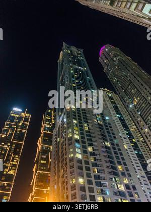 Blick auf beleuchtete Wolkenkratzer in Dubai Marina bei Nacht, mit modernen architektonischen Glasfassaden und leuchtenden Fenstern in Dubai, Dubai, United Ara Stockfoto