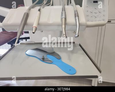 Zahnarztspiegel und Zahnhandstück auf dem Facharztstuhl. Moderne zahnärztliche Klinikausstattung für Checkup und Mundhygiene. Klinische Zahnuntersuchung Stockfoto