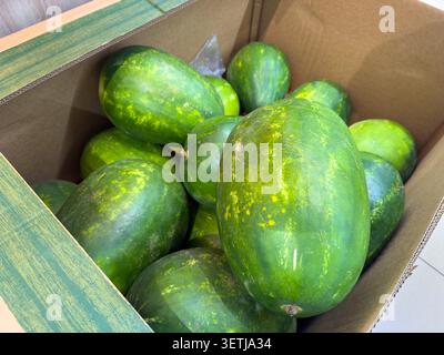 Frische Bio-Wassermelonen in einer Holzkiste auf einem Markt Stockfoto