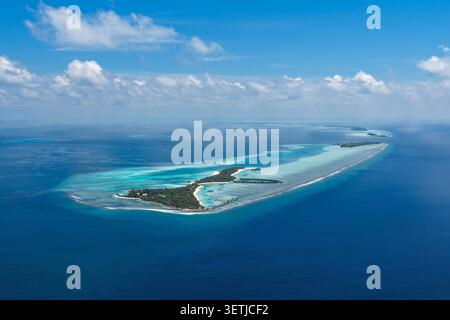 Blick aus der Vogelperspektive auf tropische Inseln mit türkisfarbenen Lagunen, weißen Sandstränden und üppiger Vegetation unter einem blauen Himmel mit verstreuten Wolken in Kudahuvadhoo Stockfoto