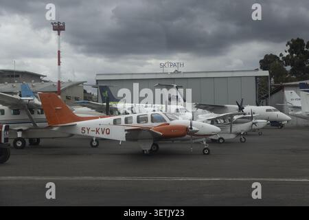 Nairobi, Kenia - 31. Mai 2026: Blick auf kleine Propellerflugzeuge, die auf dem Asphalt vor einem Hangar am Wilson Airport unter bewölktem Himmel geparkt sind. Stockfoto