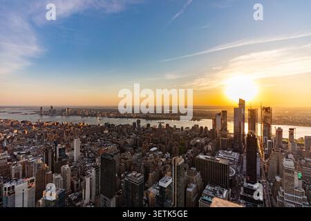 Blick auf die Skyline von New York City bei Sonnenuntergang mit Wolkenkratzern, dem Hudson River und goldenem Licht über die urbane Landschaft in New York, New York, Unite Stockfoto