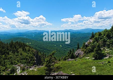 Ein atemberaubender Panoramablick zeigt die wunderschönen Berge von North Carolina, die sich zum Horizont hin unter einem dynamischen Himmel voller flauschiger Natur erstrecken Stockfoto