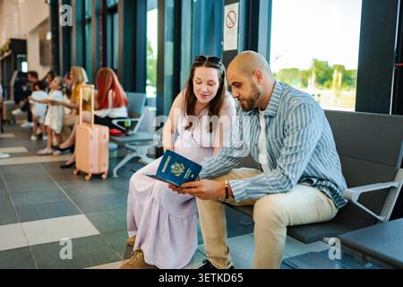 Junges erwachsenes Paar wartet am Flughafen mit Reisepass, bereit für die Reise Stockfoto