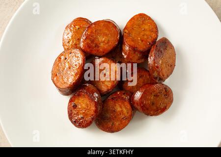 Eine Top-Down-Ansicht eines Stapels geschnittener spanischer Chorizo auf einem Teller. Stockfoto