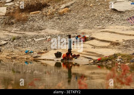 Chikkaballapur, Karnataka, Indien – 10. Dezember 2023: Mutter und Tochter waschen Kleidung an einem See in Chikkaballapur, Karnataka, Indien. Stockfoto