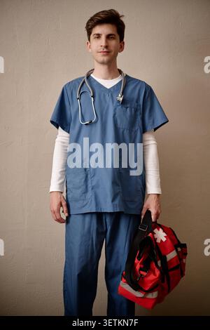 Porträt der männlichen Krankenschwester des Erwachsenen, die einen medizinischen Notfall-Beutel hält Stockfoto