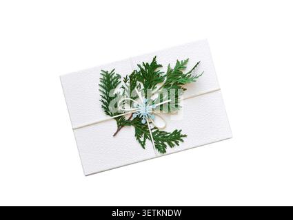 Weiße Geschenkbox DIY dekoriert für Weihnachten mit immergrünem Zweig von oben nach unten, isoliertem Ausschnitt auf weiß Stockfoto