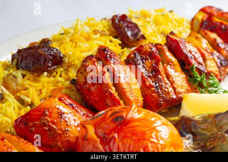 Eine Nahaufnahme eines Tellers Hühnerkabob mit Rosinenreis. Stockfoto