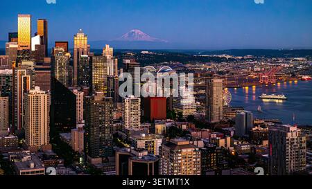 Luftaufnahme von Seattle, Washington, Skyline in der Abenddämmerung, mit Wolkenkratzern in der Innenstadt und Mount Rainier am Abend Stockfoto