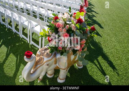 Dekorative Elefantenstatue in weiß und Gold mit Blumenarrangements bei einer indischen Hochzeitsfeier im Freien Stockfoto
