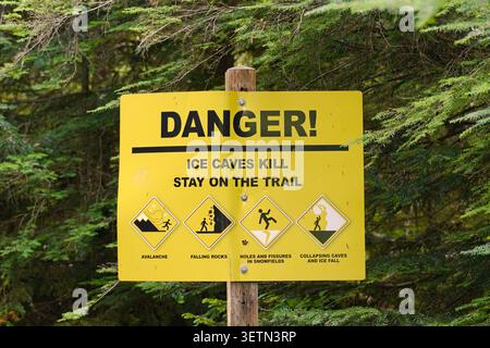 Warnschild auf dem Big Four Ice Caves Trail, das Wanderer vor Lawinengefahr, herabfallenden Felsen, Gefahren für Schneefelder und einstürzenden Eishöhlen warnt. Stockfoto