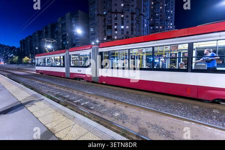 St. Petersburg, Russland - 11. September 2025: Moderne Straßenbahn auf der Stadtstraße von St. Petersburg in der Sommernacht. Elektrofahrzeug für öffentliche Verkehrsmittel Stockfoto