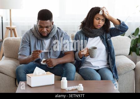 Behandlung Des Coronavirus Zu Hause. Krankes Schwarzes Paar, Das An Covid-19-Symptomen Leidet Stockfoto