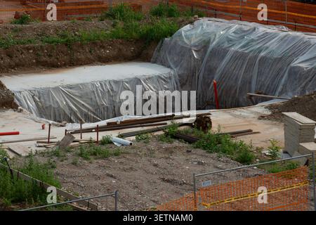Nahaufnahme einer Baustelle mit Stahlverstärkungsgittern, hölzernen Schalungsplatten und tragenden Elementen in der Entwicklung. Stockfoto